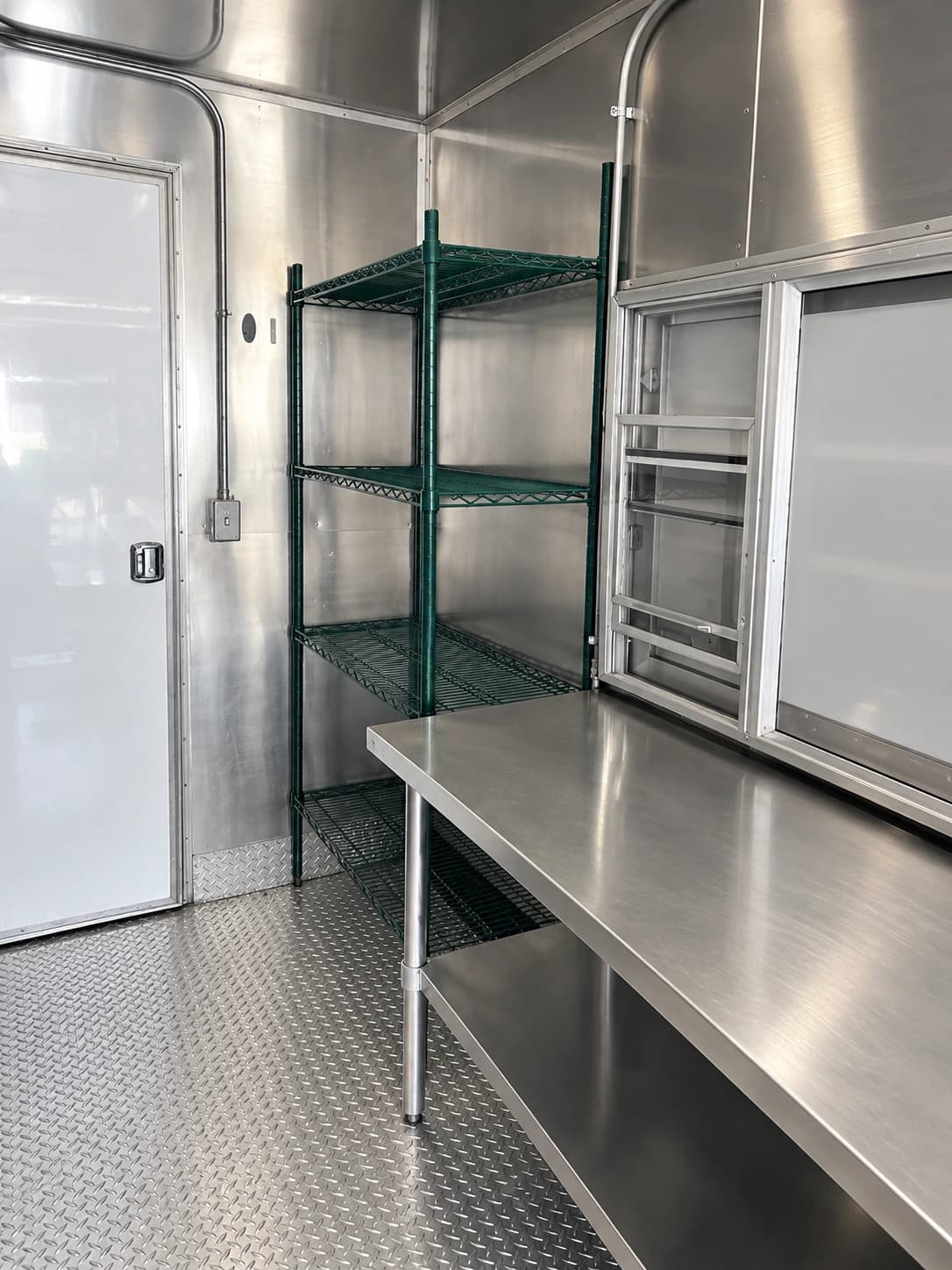 Portable kitchen trailer stainless prep table shelving.